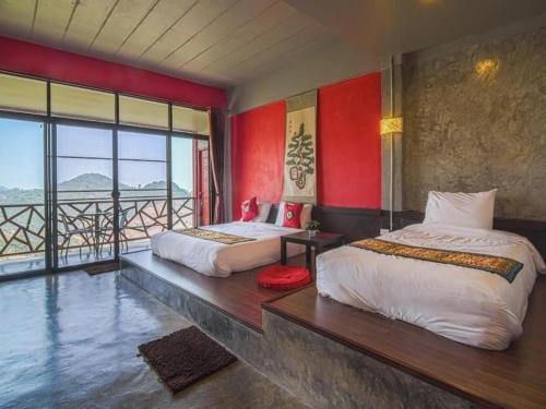 a hotel room with two beds and a balcony at Wang Put Tan Boutique House in Mae Salong