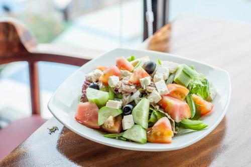 een salade op een wit bord op een tafel bij RS II Guesthouse in Phnom Penh