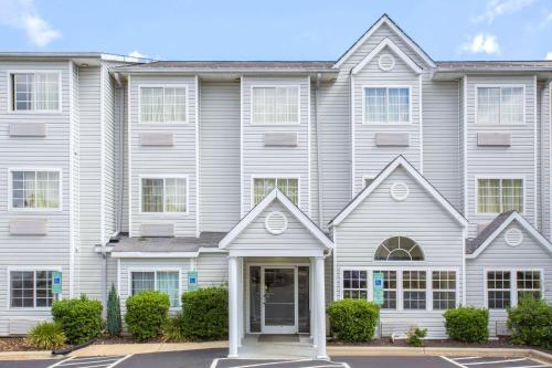 a large house with white siding at Microtel Inn & Suites by Wyndham Kannapolis/Concord in Kannapolis
