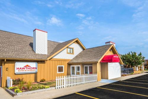 a fast food restaurant with a white fence in a parking lot at Hawthorn Extended Stay by Wyndham Dayton in Dayton