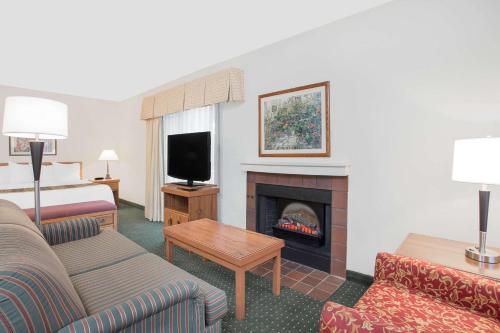 a hotel room with a living room with a fireplace at Hawthorn Extended Stay by Wyndham Green Bay in Green Bay