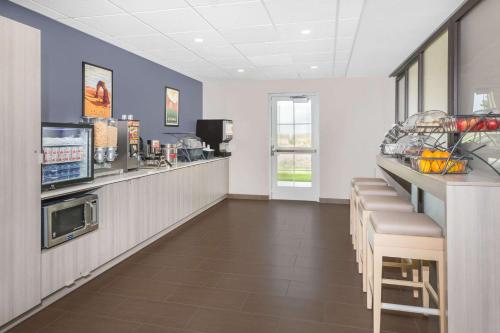 a bar in a restaurant with a counter and chairs at Microtel Inn & Suites by Wyndham Springville in Springville