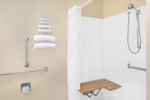 a bathroom with a shower and a toilet with towels at Microtel Inn and Suites Clear Lake in Clear Lake