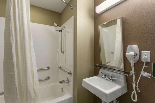 a bathroom with a shower and a sink and a mirror at Microtel Inn & Suites by Wyndham Minot in Minot