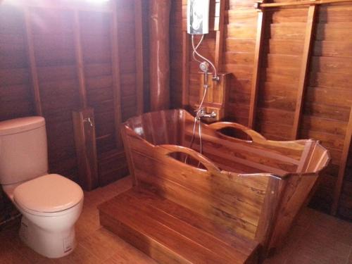a wooden bathroom with a toilet and a wooden tub at Huanmaisakngam Resort in Ban Buak Khang