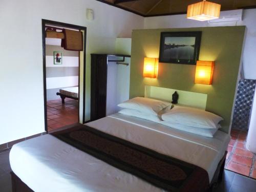 a bedroom with a large bed with a mirror at Raingsey Bungalow in Kep