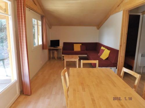 Tuchan的住宿－Les chalets du Relais d'Aguilar，客厅配有桌子和沙发