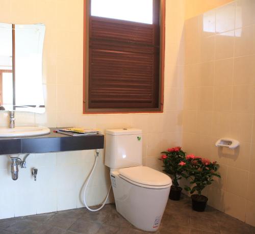 ノンナムデンにあるThongsathit Hill Resort Khao Yaiのバスルーム(トイレ、洗面台付)、窓が備わります。