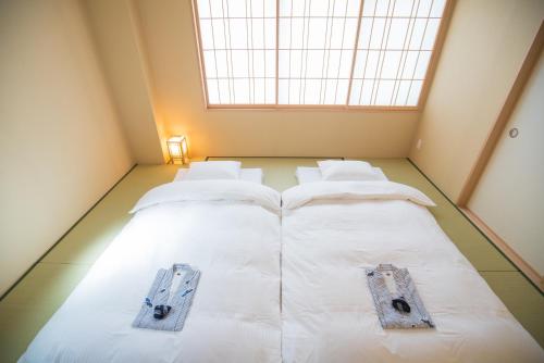 two beds in a room with a large window at Hotel Yu-shu in Osaka