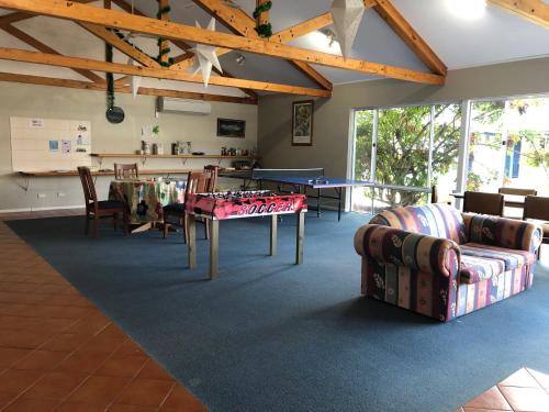 sala de estar con mesa de ping pong y sillas en Busselton Ithaca Motel en Busselton