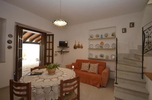 ein Wohnzimmer mit einem Tisch und einem Sofa in der Unterkunft Baglio Fontana in Castelluzzo