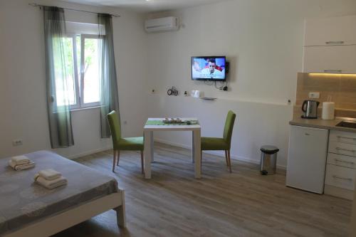 a room with a table and chairs and a kitchen at Apartments Grgurević in Kotor