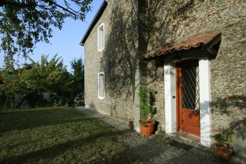 a brick building with a wooden door and a yard at Casa nel verde in Decollatura