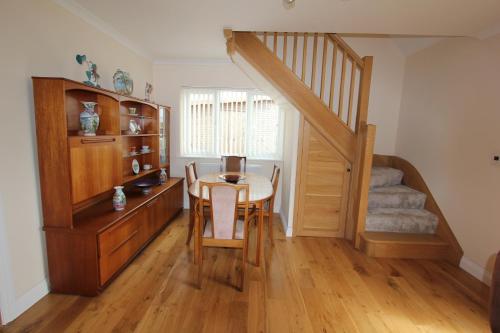 a dining room with a table and a staircase at Glenside Cottage with Hot Tub in Solva