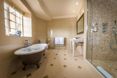 a bathroom with a tub and a shower and a sink at Greywalls Hotel & Chez Roux in Gullane