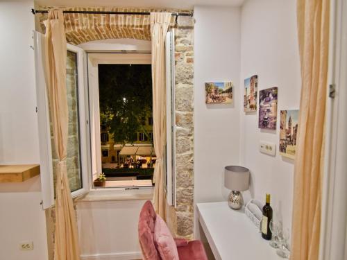 a room with a window and a table with a lamp at Luxury room Colonna 4*, center in Zadar