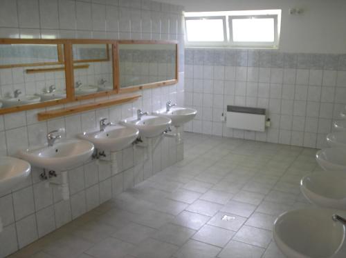 Baño con una fila de lavabos y espejos en Rekreační komplex Losinka en Velké Losiny