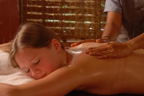 Eine Frau bekommt eine Massage in einer Badewanne in der Unterkunft Uday Suites - The Airport Hotel in Thiruvananthapuram