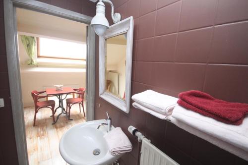 een badkamer met een wastafel, een spiegel en een tafel bij Comme à la Ferme in Durbuy