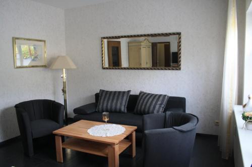 a living room with a couch and two chairs and a table at Pension / Ferienwohnung Allebrodt in Lennestadt