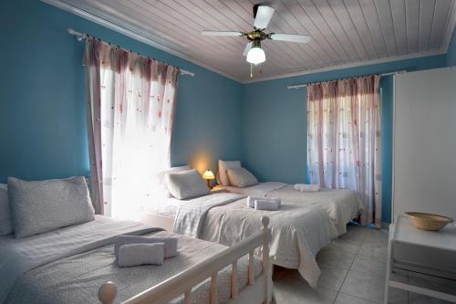 una camera con 2 letti e un ventilatore a soffitto di Mikroulis Residence a Mastorátika