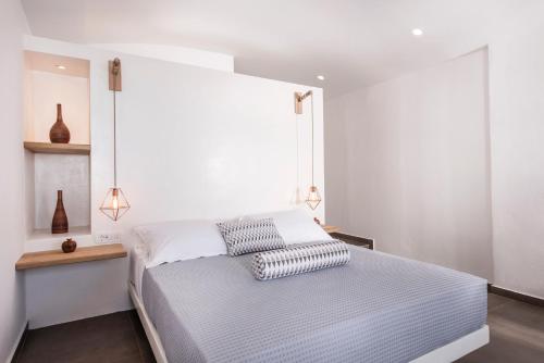 a bedroom with a bed with two pillows on it at Caldera's Memories in Imerovigli