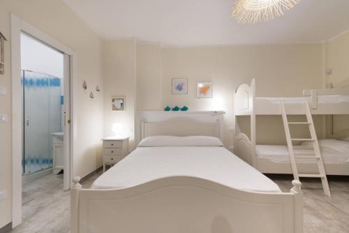 um quarto branco com um beliche e uma escada em Casa Vacanze Poseidone em Lido Conchiglia