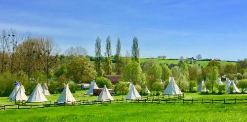 un gruppo di tende bianche in un campo di Les Tipis du Bonheur de Vivre a Brûlon