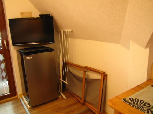 a small refrigerator in a corner with a flat screen tv at Przy Szlaku Zakopane centrum pokoje & apartamenty in Zakopane