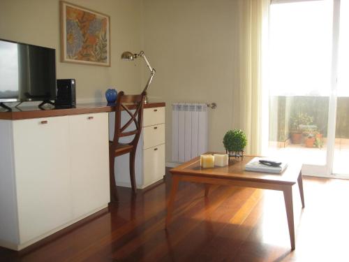 a living room with a table and a tv at Casa do Terraço in Aveiro