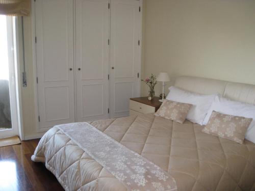 アヴェイロにあるCasa do Terraçoのベッドルーム1室(大型ベッド1台、白いシーツ、枕付)