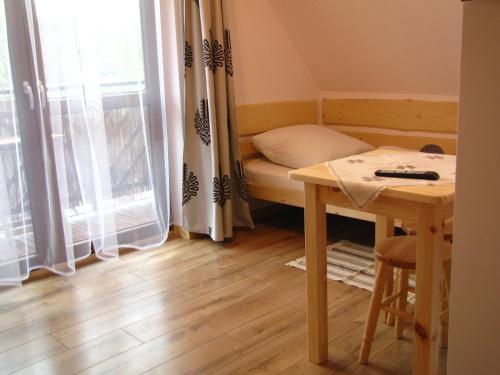 a small room with a table and a bed and a window at Przy Szlaku Zakopane centrum pokoje & apartamenty in Zakopane
