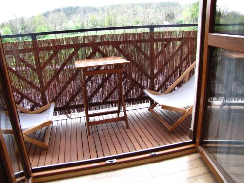 a balcony with two chairs and a table at Przy Szlaku Zakopane centrum pokoje & apartamenty in Zakopane