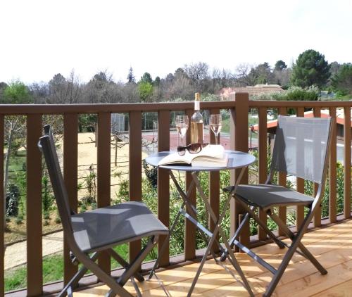 a table and two chairs on a deck at Hotel Les Ambres in Roussillon