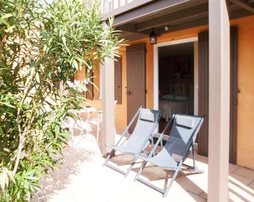 two chairs on the porch of a house at Hotel Les Ambres in Roussillon
