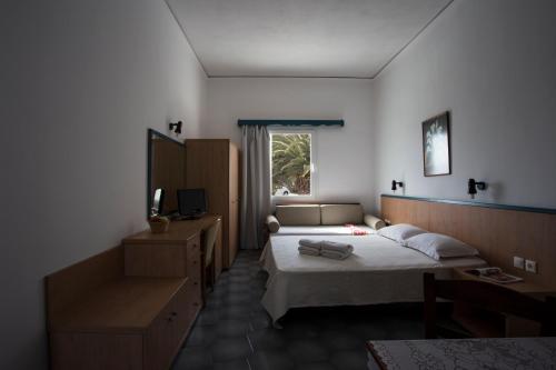 a hotel room with two beds and a television at SUN -RISE in Perissa