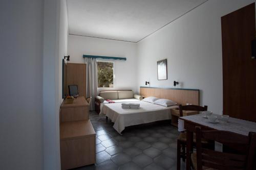 1 dormitorio con 1 cama y 1 mesa en una habitación en SUN -RISE en Perissa