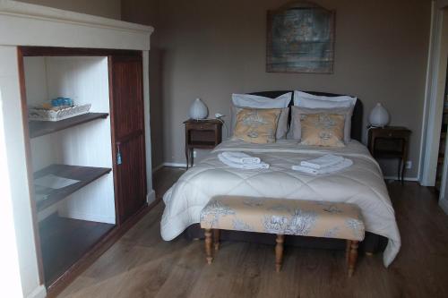 een slaapkamer met een groot bed en twee nachtkastjes bij La Cochetière in Cheviré-le-Rouge