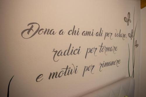 a sign on a wall with writing on it at B&B Valtilí in Berzo