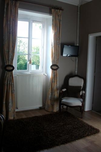 a living room with a chair and a window at La Cochetière in Cheviré-le-Rouge