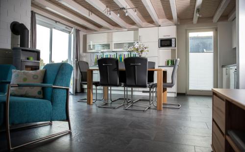 een woonkamer met een eettafel en stoelen bij Ferienhaus Nordhorn - Haus Am See in Nordhorn