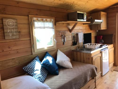 - une petite cuisine avec un banc dans une petite maison dans l'établissement La roulotte au fond du pré, à Coltines