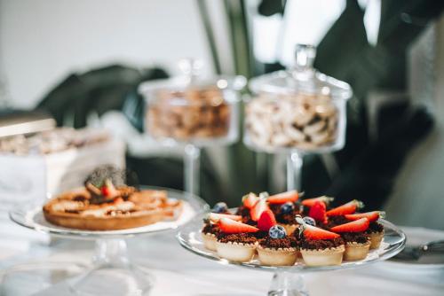 two plates of desserts on a table with wine glasses at Hotel Villa Fanny in Cagliari