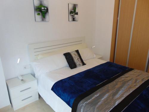 a bedroom with a bed with a blue and white bedspread at Marina d’Or Beachfront-Vista al mar frontal in Oropesa del Mar