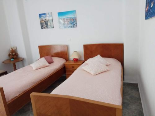 a bedroom with two beds and a night stand at Anastasia - Efthimios Apartments in Agios Konstantinos