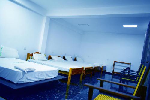 a room with two beds and a table and chairs at Hotel Green Garden in Trincomalee