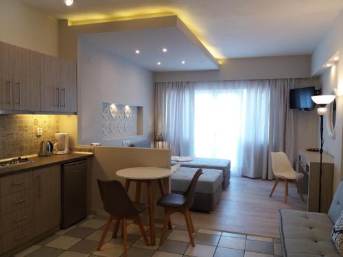 eine Küche und ein Wohnzimmer mit einem Tisch und Stühlen in der Unterkunft Irida Studios in Ágios Dimítrios