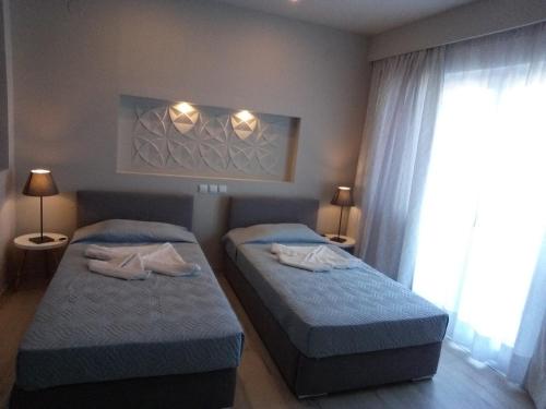 a bedroom with two beds and a window at Irida Studios in Ágios Dimítrios