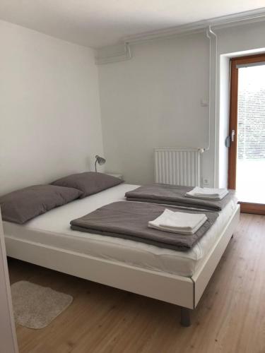 a large bed in a white room with a window at Katarina in Bled