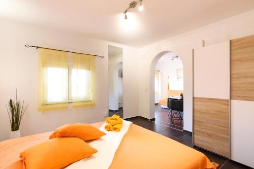 una camera da letto con un grande letto con cuscini arancioni di Studio Apartment Maslina a Gornji Karin (Carino)
